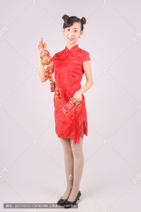 微笑的年轻女人拿着一串鞭炮装饰品