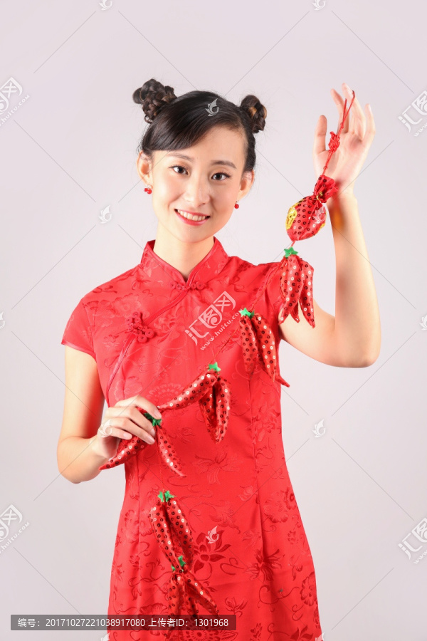 女人微笑着拿着红辣椒挂饰