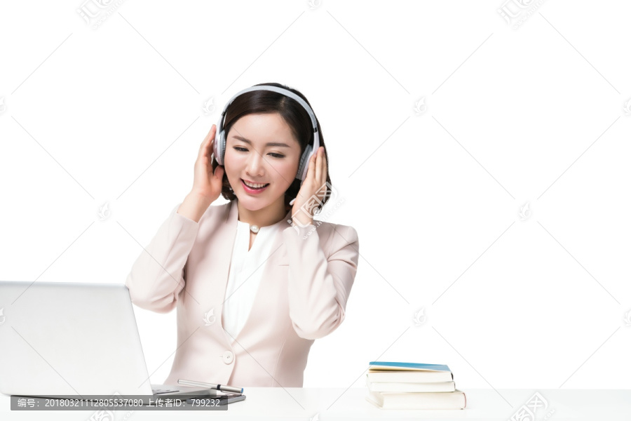 年轻女子戴着耳机使用电脑