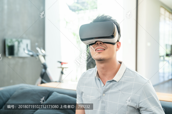 年轻男子在沙发上使用VR眼镜