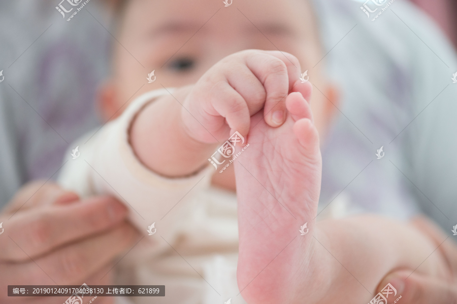 婴儿的手握着自己的脚丫