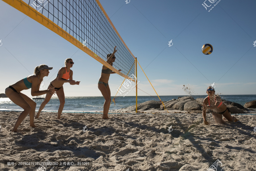 女子排球运动员在沙滩上打排球