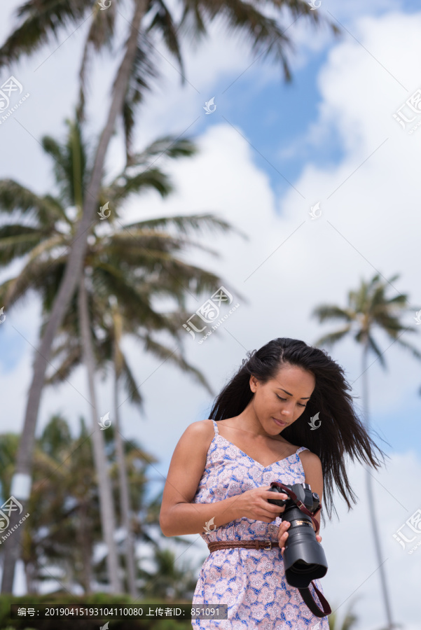 在海滩上查看照片的女人