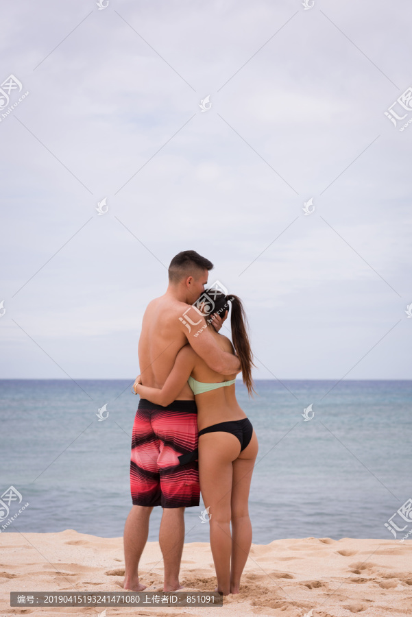 在沙滩上拥抱的夫妻