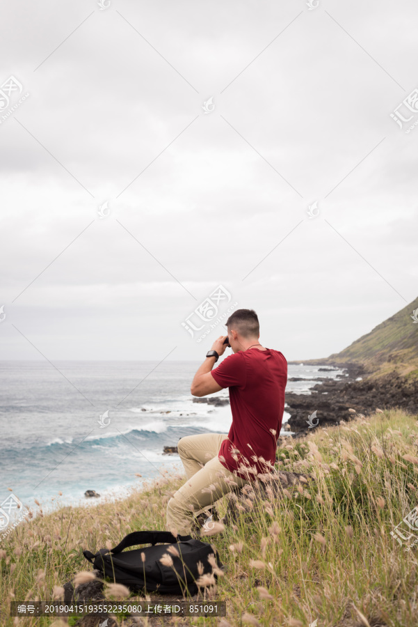 徒步旅行的男人用望远镜看风景