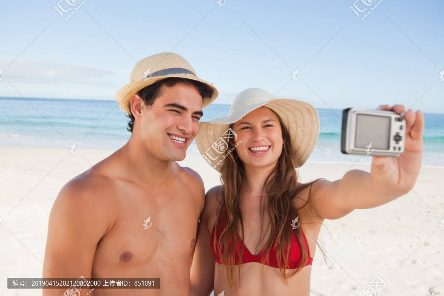 微笑情侣在海滩上合影
