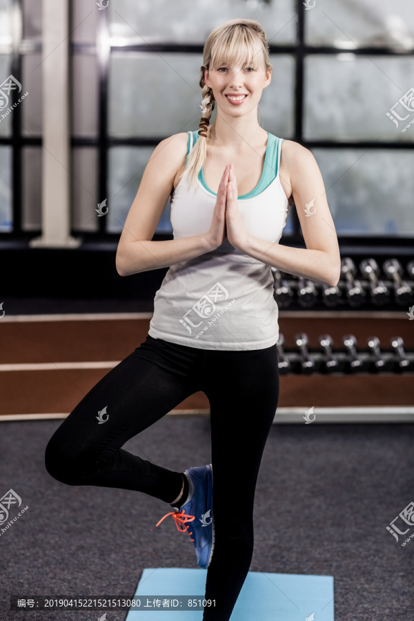 微笑的女人在休闲中心做瑜伽练习