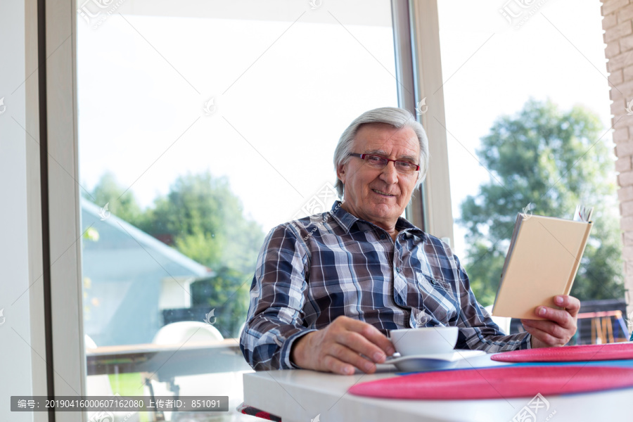 老人在客厅看书喝咖啡