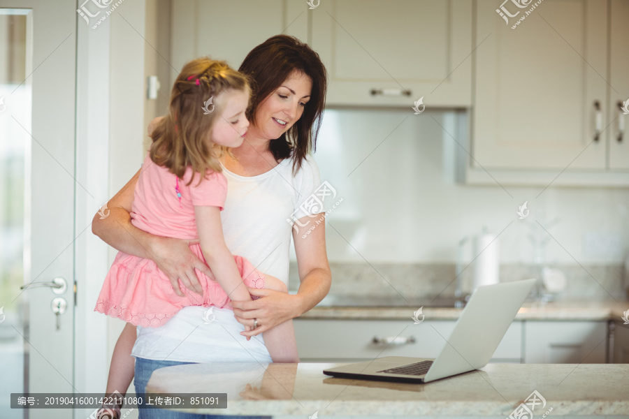 妈妈和女儿在家看笔记本电脑