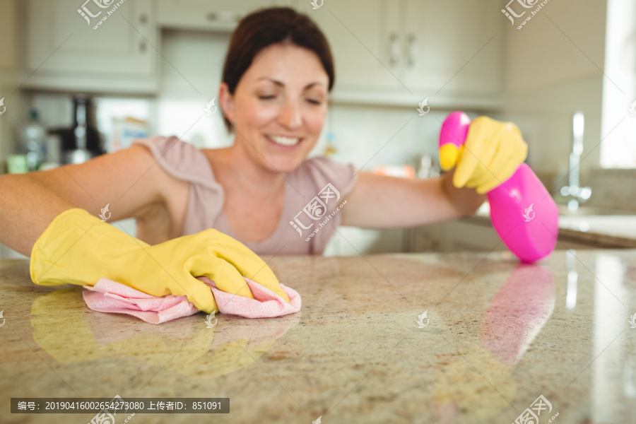 妇女用橡胶手套布清洁厨房台面
