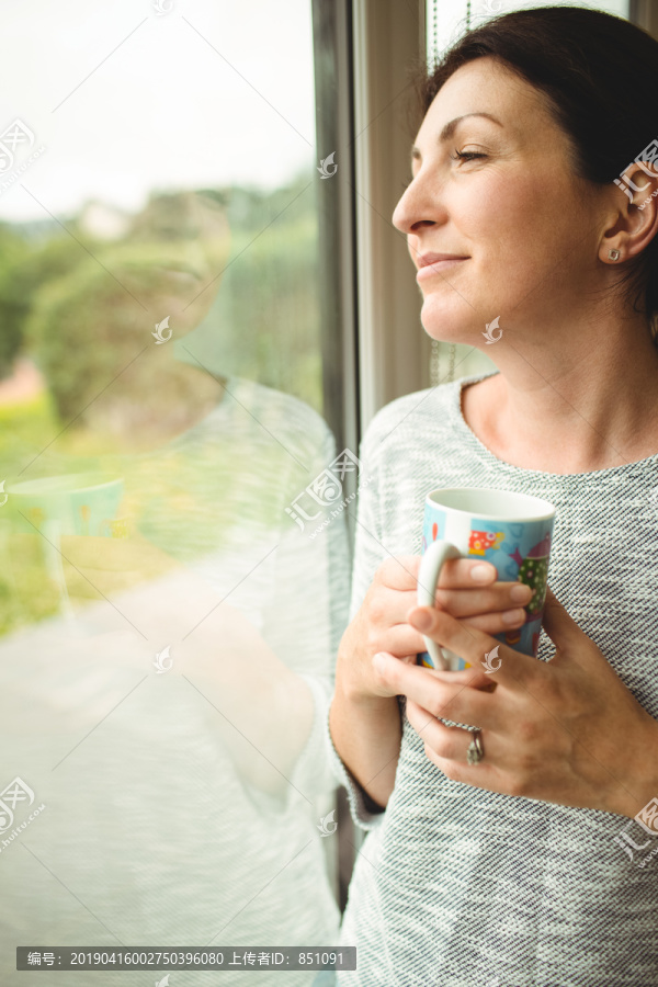 透过窗户看咖啡杯女人的肖像