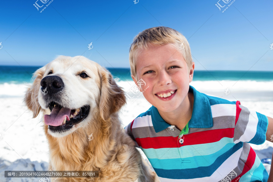 可爱的男孩在海滩上爱狗
