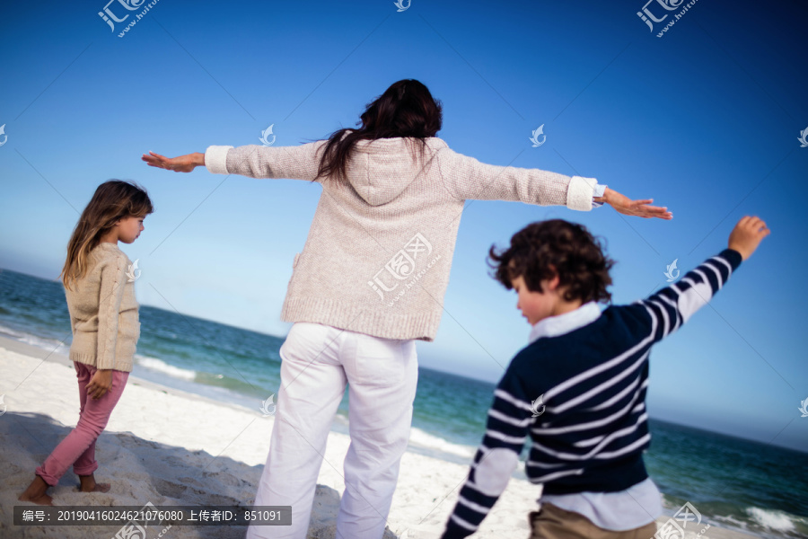 海滩上伸出双臂的可爱家庭