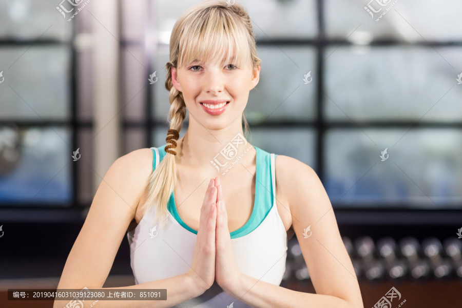 微笑的女人在休闲中心做瑜伽练习