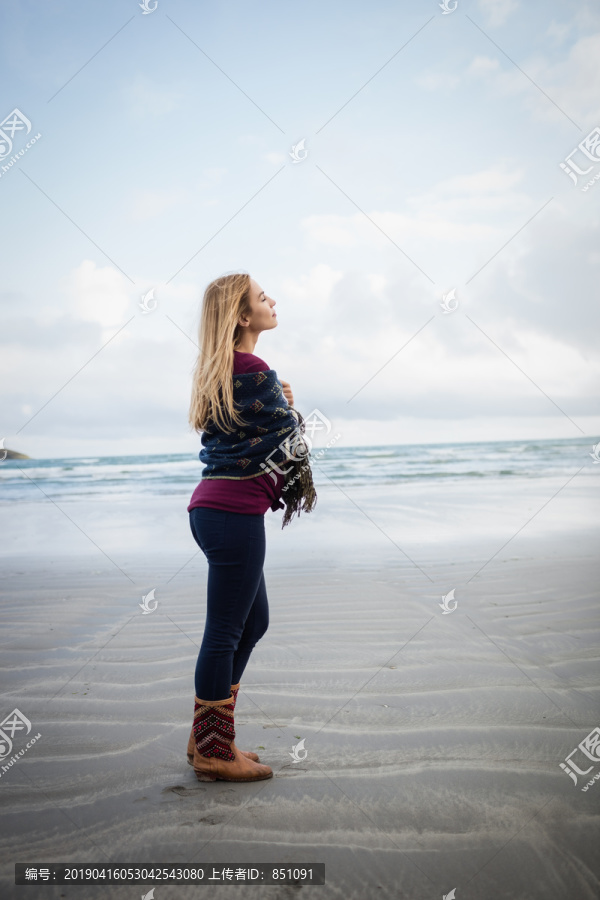 美丽的金发女人在海岸线放松