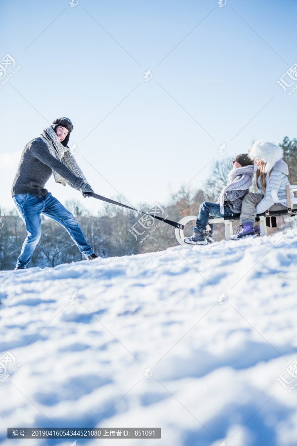 父亲和孩子们玩雪橇