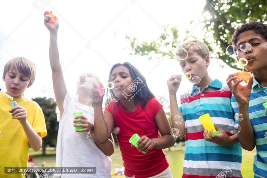 孩子们在公园里吹泡泡棒