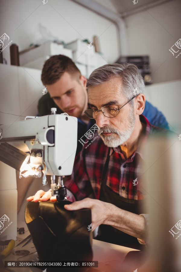 年轻鞋匠观察老年人工作的肖像