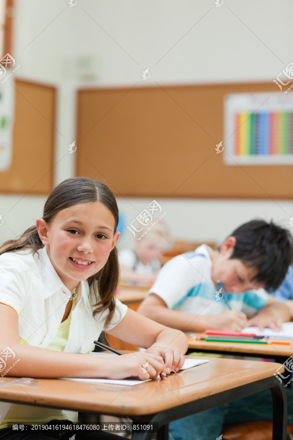 坐在桌旁微笑的小学生