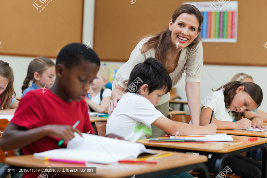 微笑小学教师帮助学生的侧视