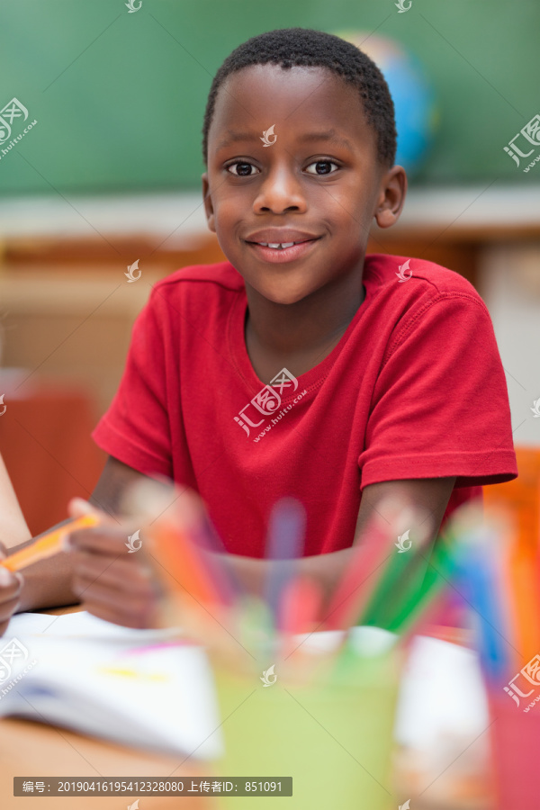 上课时坐在课桌旁微笑的小学生