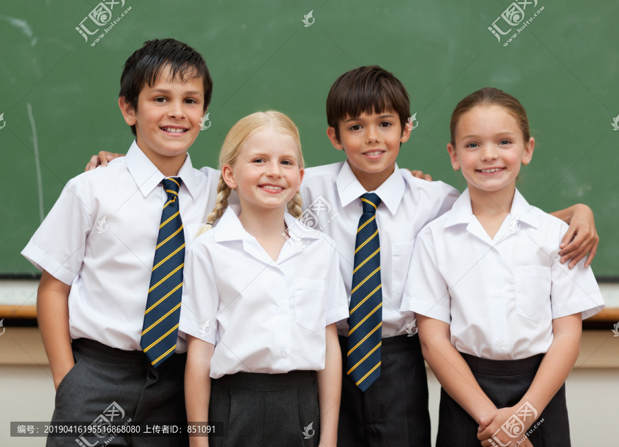 微笑着的年轻学生站在黑板前
