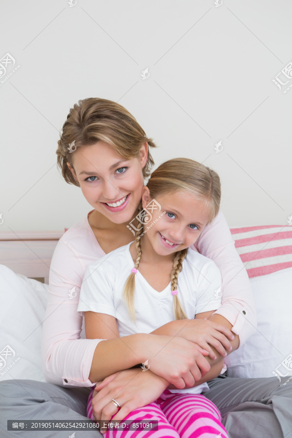 妈妈和女儿在卧室里用平板电脑