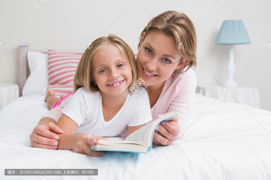 妈妈和女儿一起在卧室的床上看书