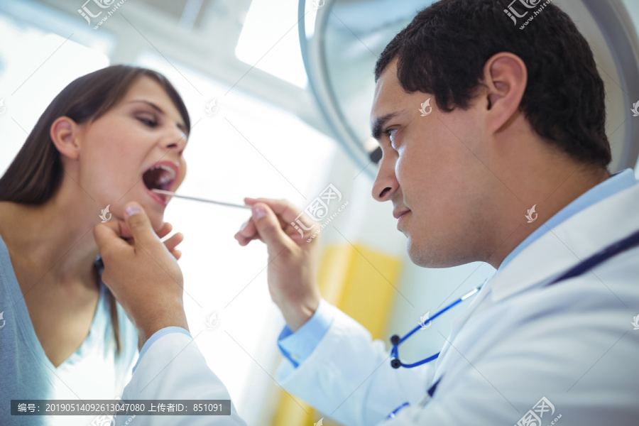 护士在医院检查女性患者的口腔
