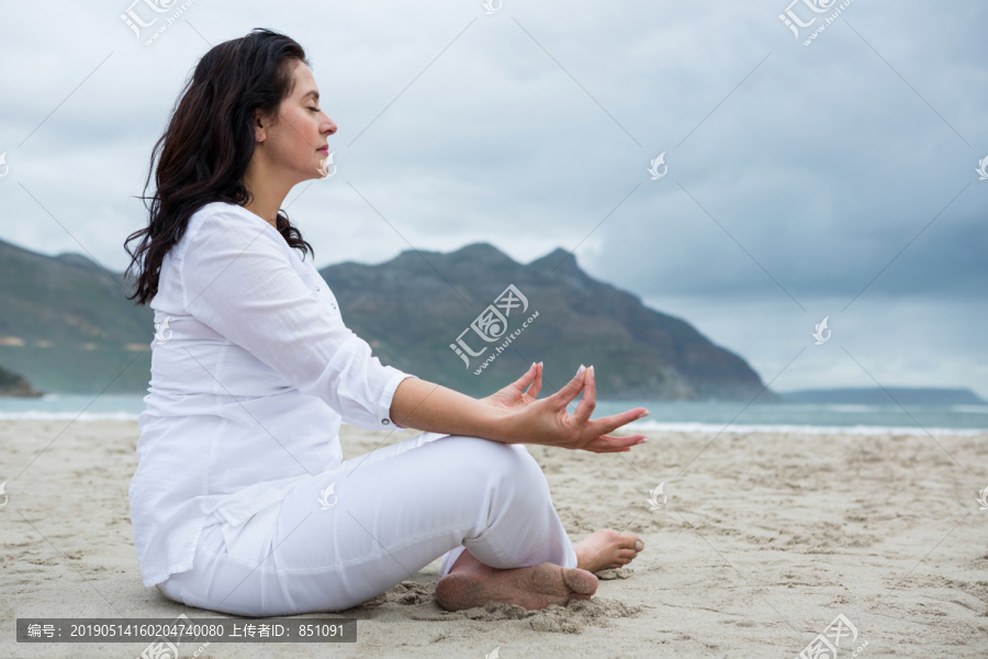妇女在海滩上做瑜伽