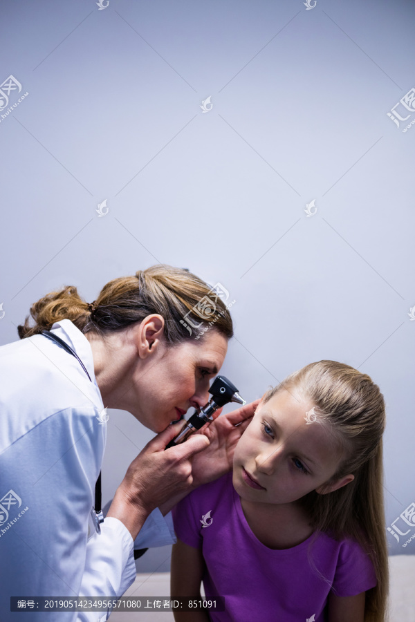 女医生用耳镜检查病人的耳朵