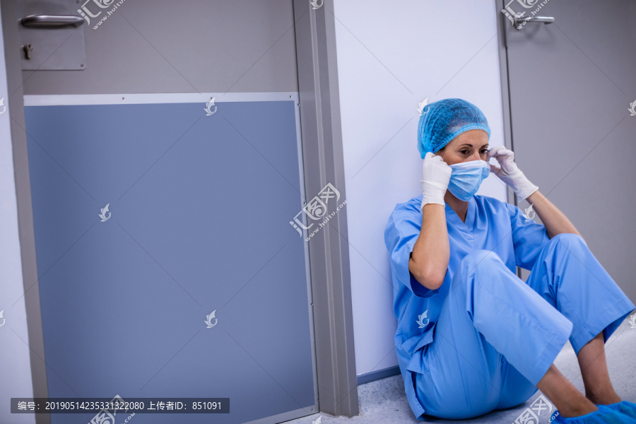 坐在医院走廊上的外科医生