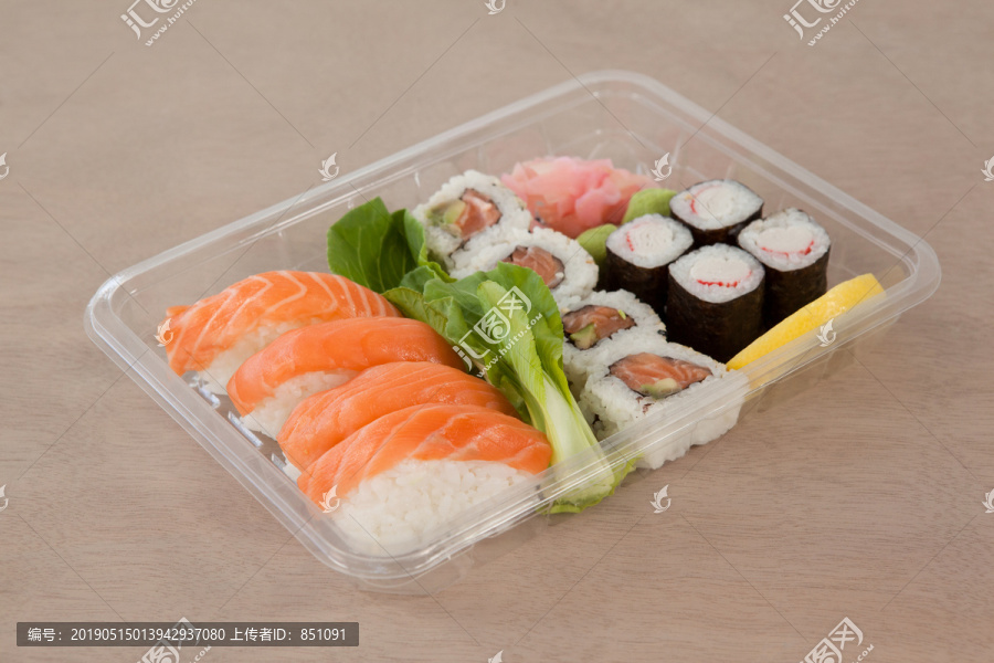 一套什锦寿司放在白底黑圆盒子里
