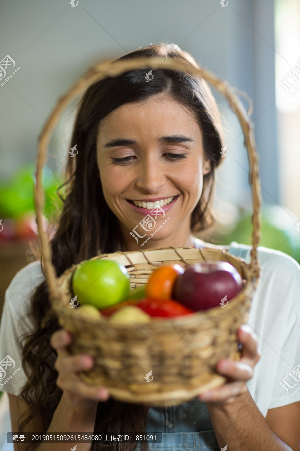 拿着一篮子水果的年轻女人