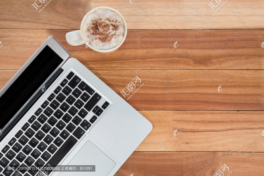 桌上的咖啡杯和笔记本电脑