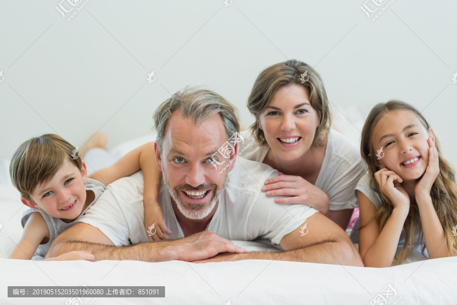家中卧室卧床上的微笑家庭
