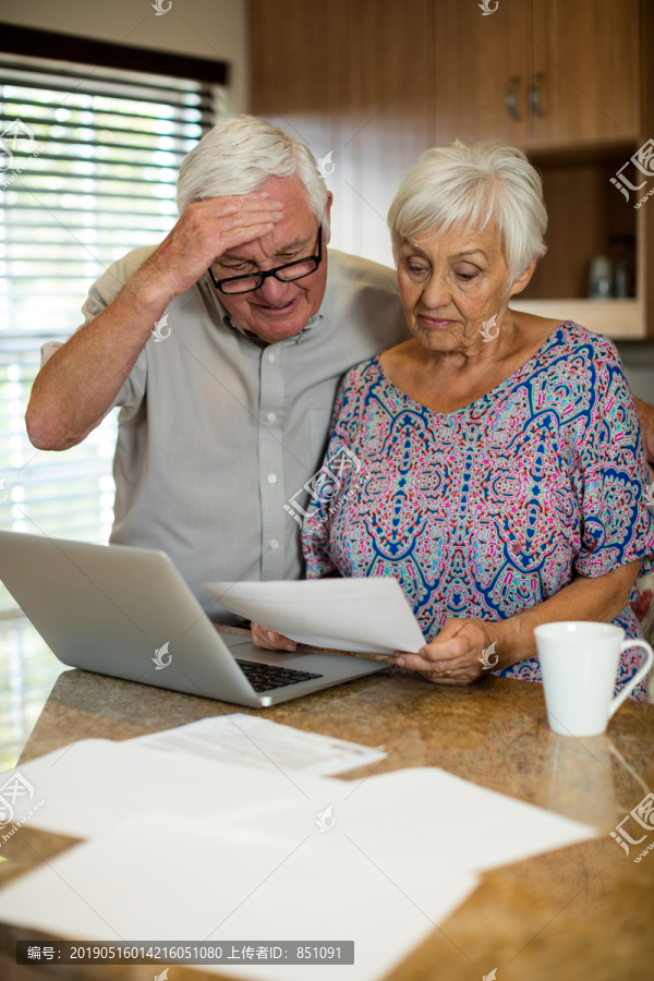 用笔记本电脑计算的老年夫妇