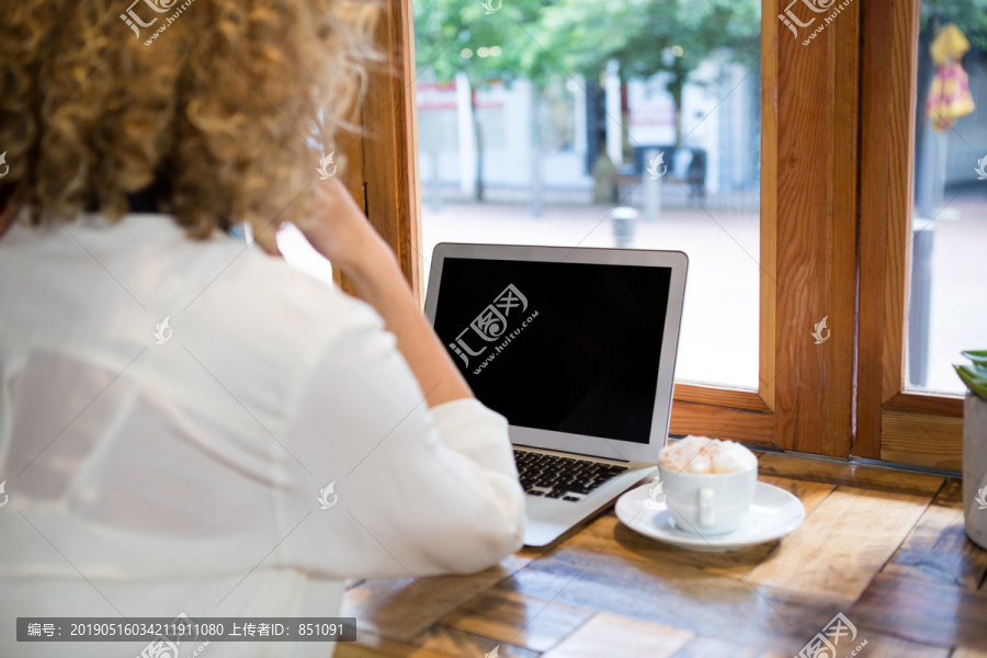 坐在咖啡馆里的年轻女性
