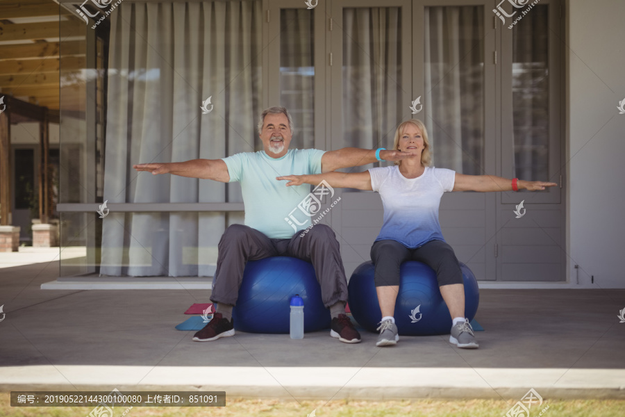 老年夫妇在健身球上做伸展运动