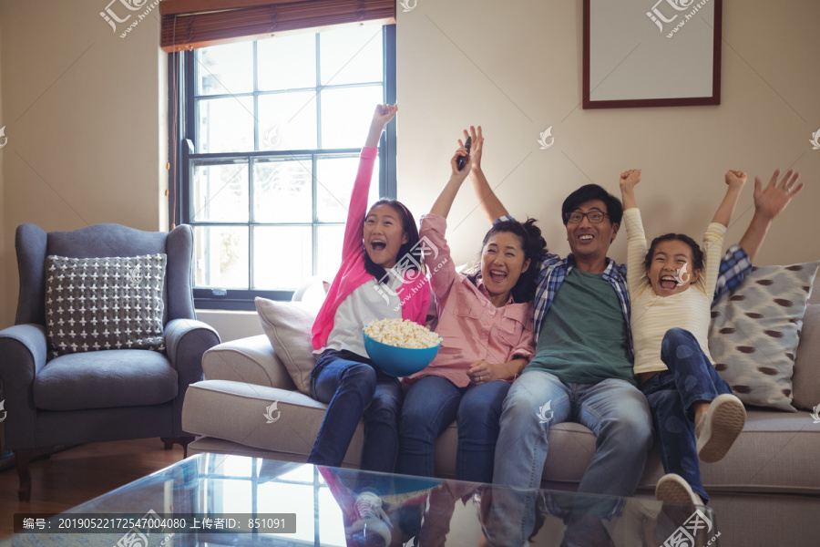 微笑的家人在客厅一起看电视