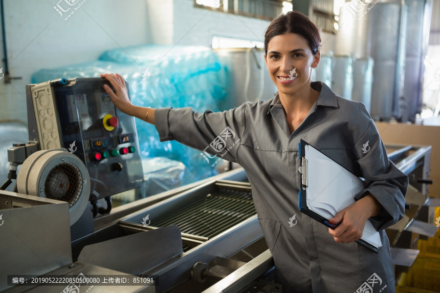 橄榄工厂的一名妇女站在机器旁