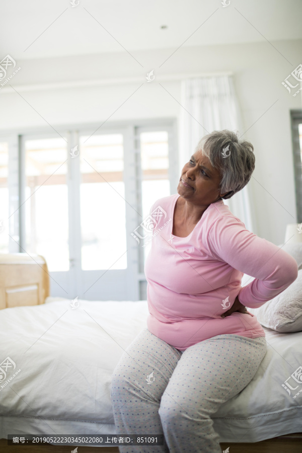 老年妇女在家里卧室背痛