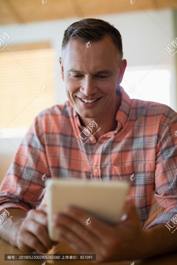 餐馆中使用平板电脑的微笑男人