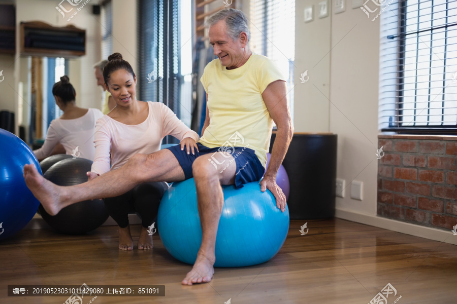 治疗师帮助老年患者进行腿部运动