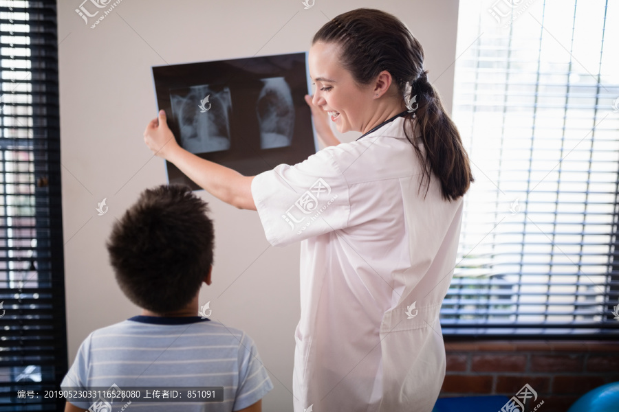 女医生对着墙给男孩看X光片