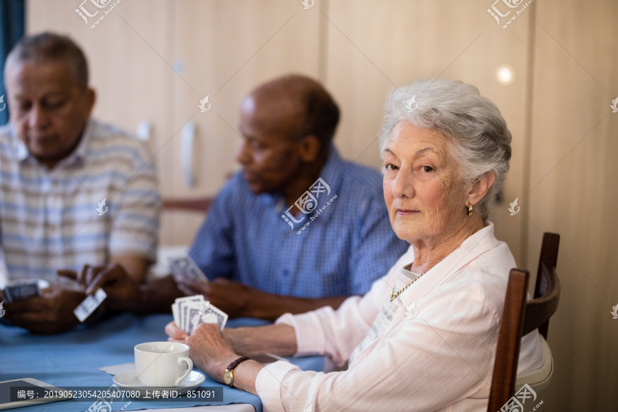 打牌的微笑的老年男女