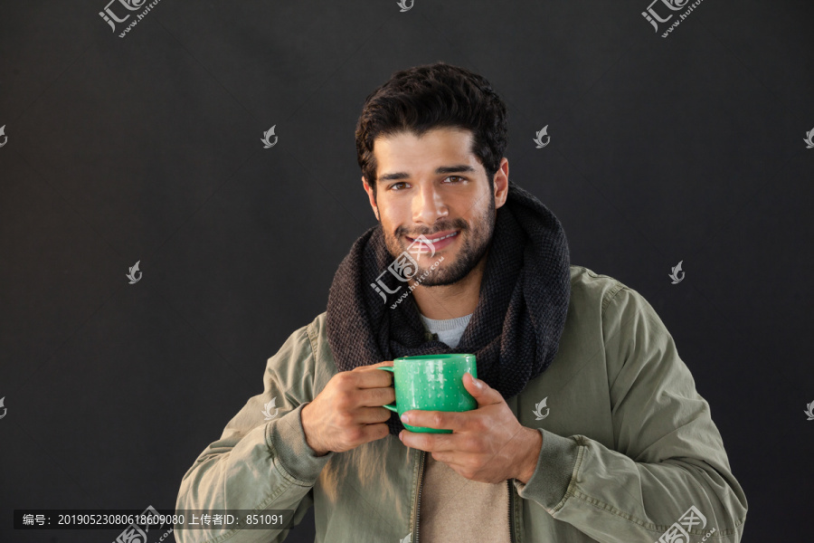 微笑的男人拿着一杯咖啡