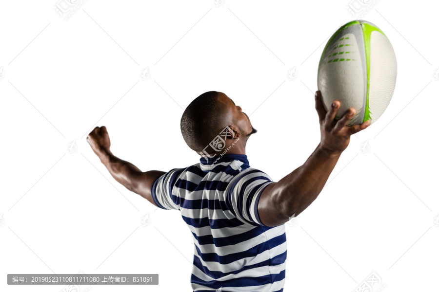 举着橄榄球伸着手臂的运动员