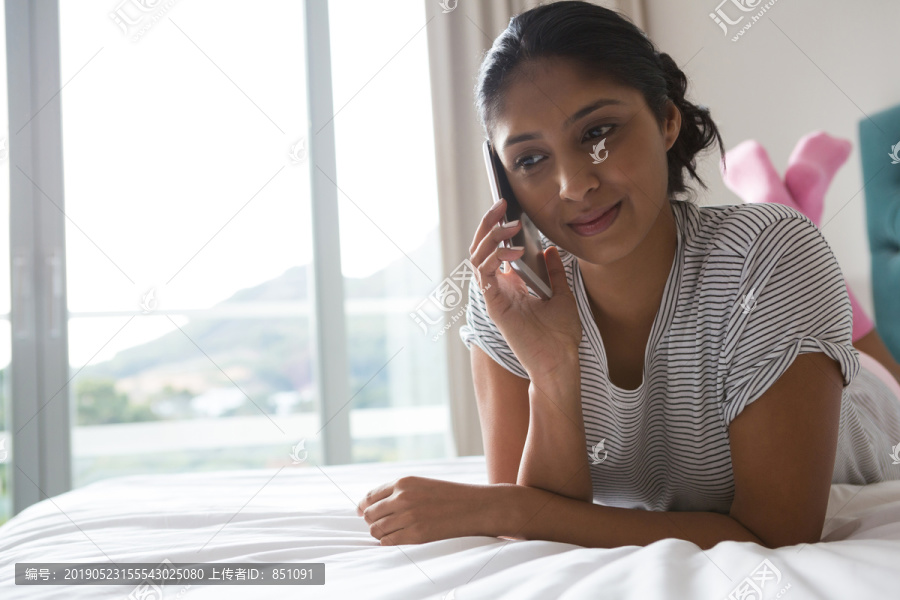 在床上使用电话的女人
