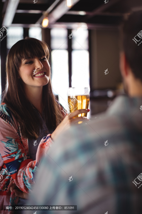 在酒吧柜台喝啤酒的夫妻互动